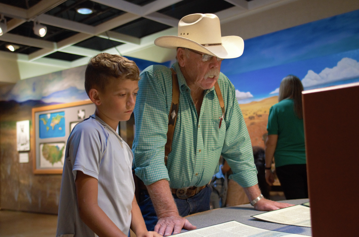 Grandfather with grandchild visiting museum exhibit